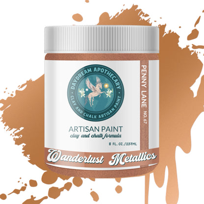 Artisan paint jar with 'Wanderlust Metallics' label on a brown paint splatter background
