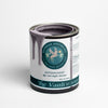 A can of purple gray chalk paint and clay paint with a brush showing the paint's consistency.